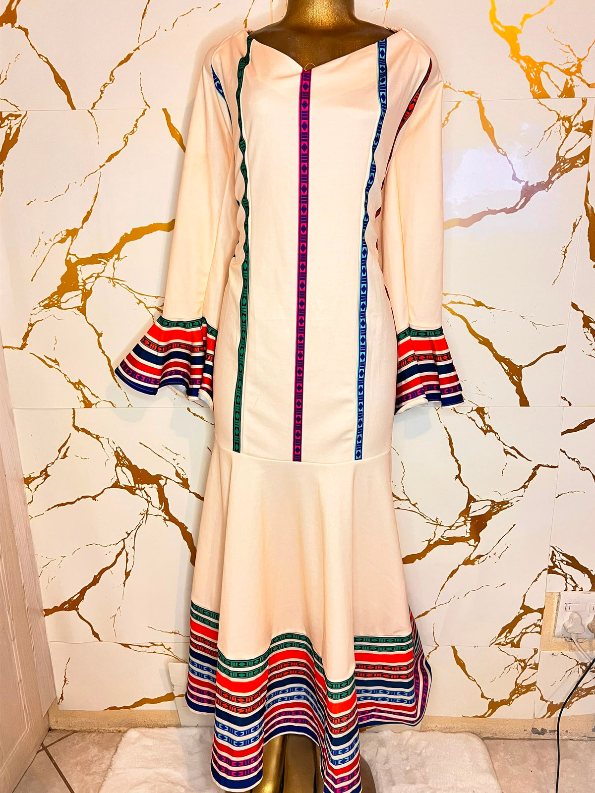 Cream-colored dress features colorful striped details