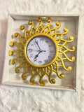 A decorative wall clock with a gold sunburst frame