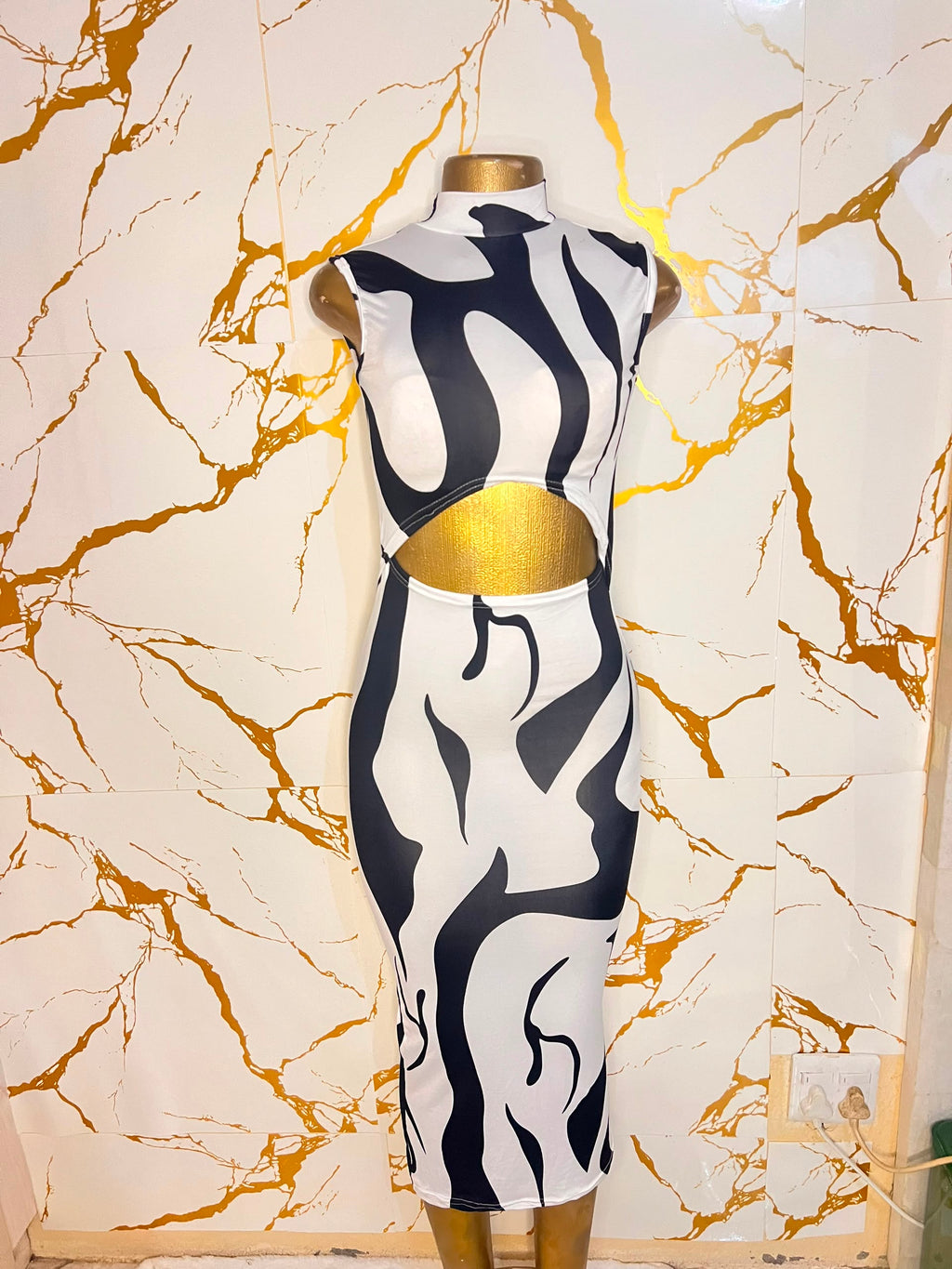 A sleeveless bodycon dress featuring a bold black and white abstract wavy pattern 