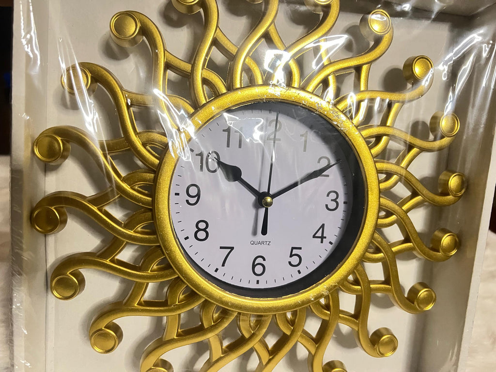 A decorative wall clock with a gold sunburst frame