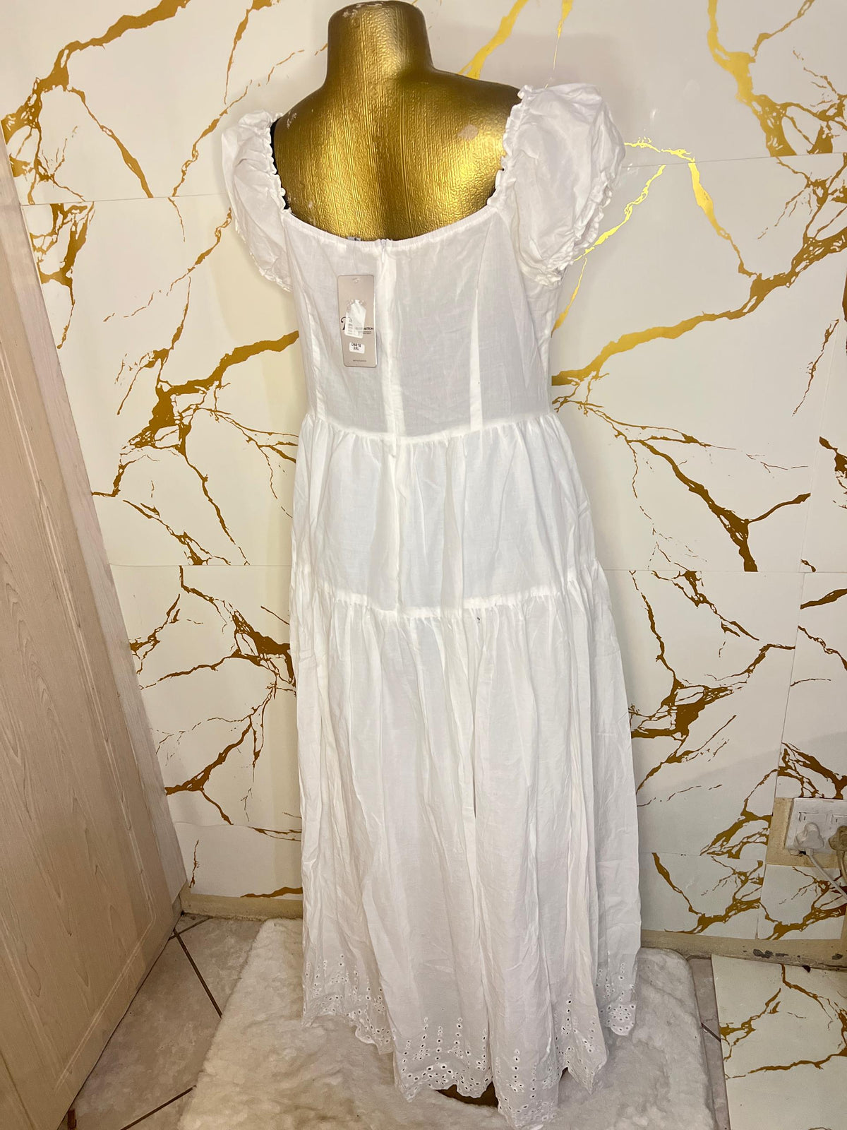 A white tiered dress with a sheer mesh corset-style bodice and ruffled cap sleeves