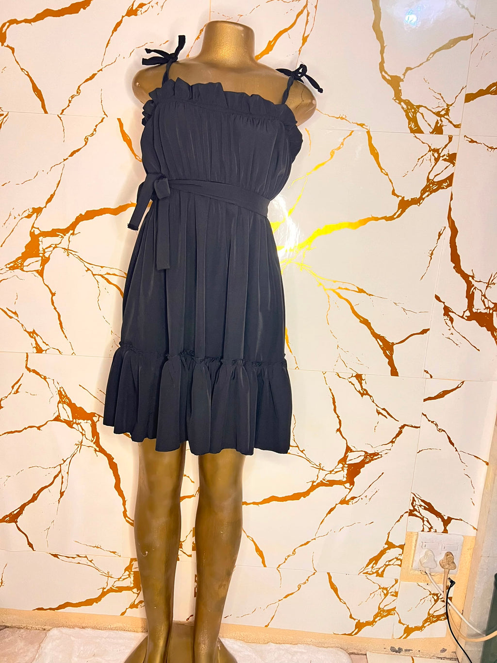 A black sleeveless ruffled mini dress