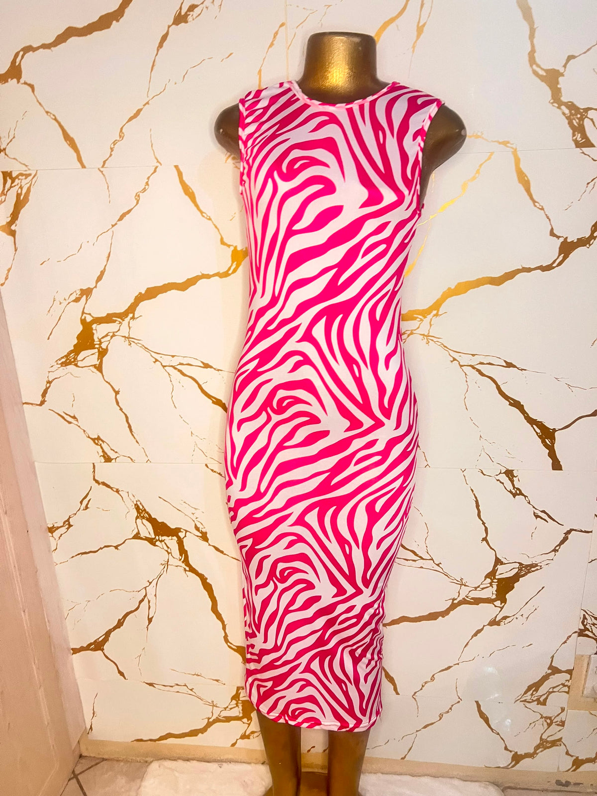 A sleeveless bodycon dress with a bold pink and white zebra-like pattern