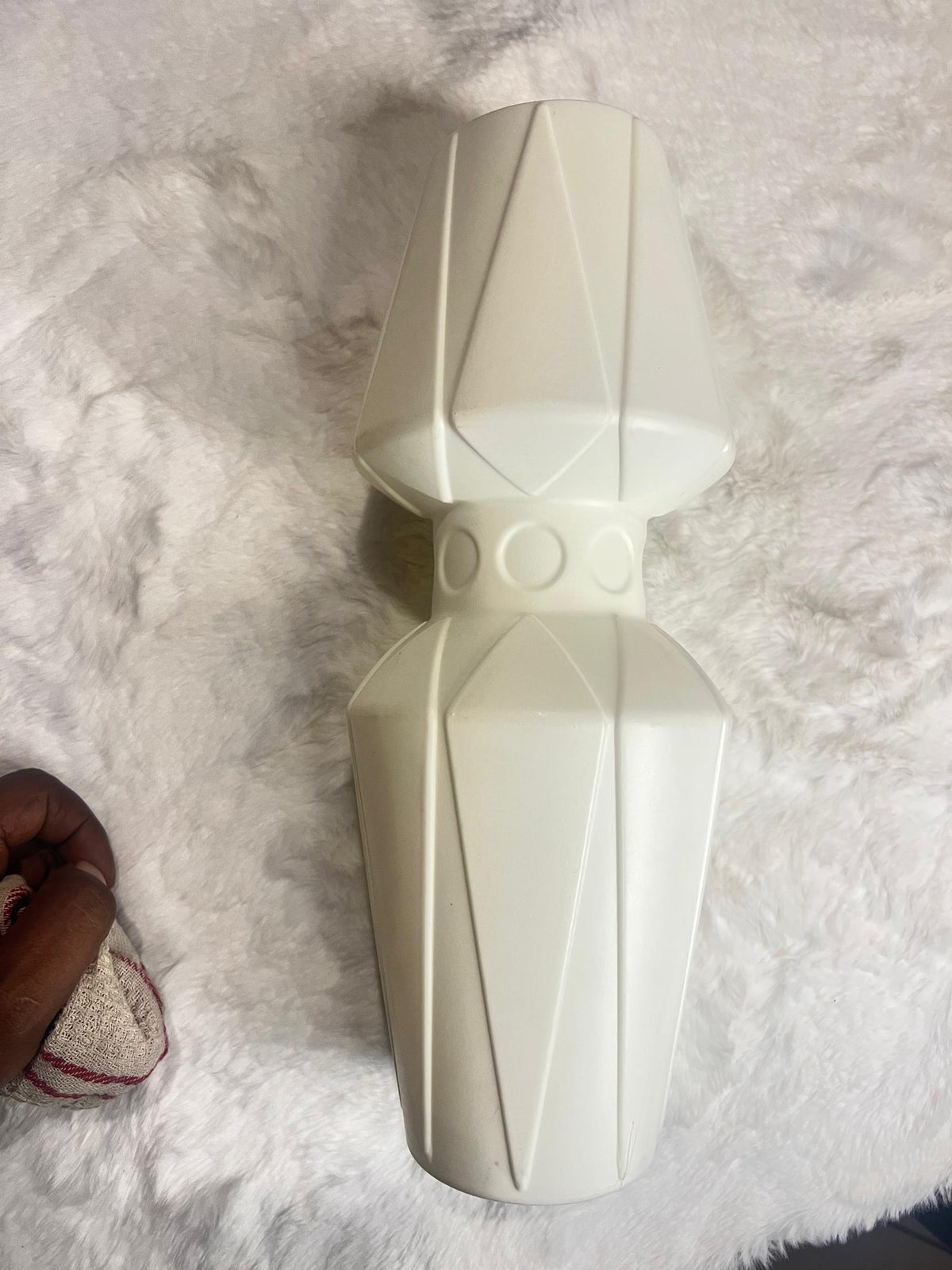 A cream-colored geometric decorative vase