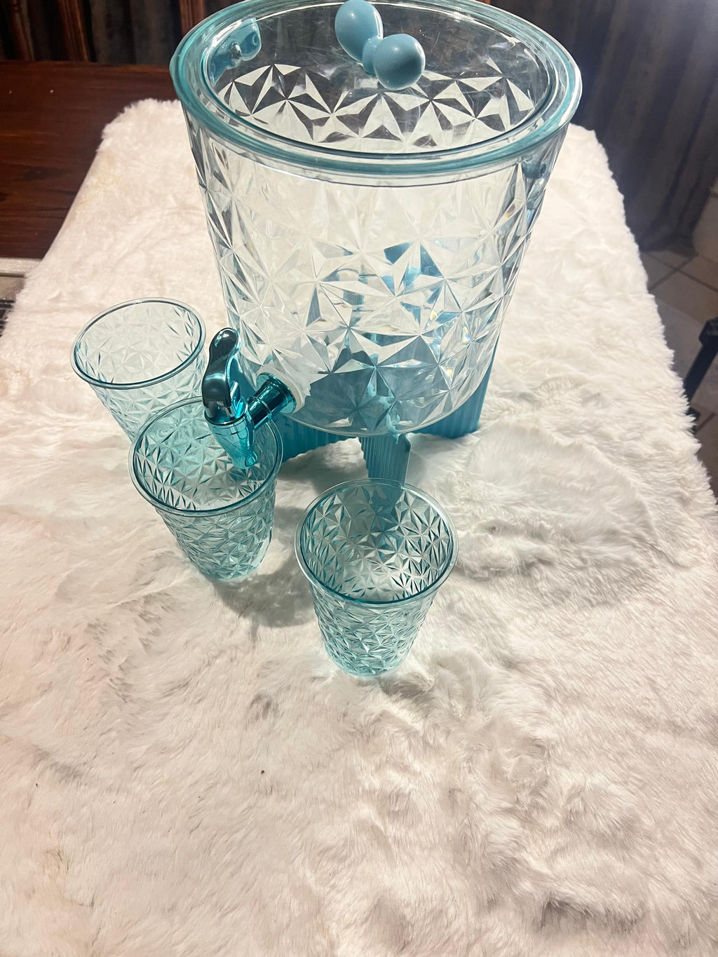 A light blue glass beverage dispenser 