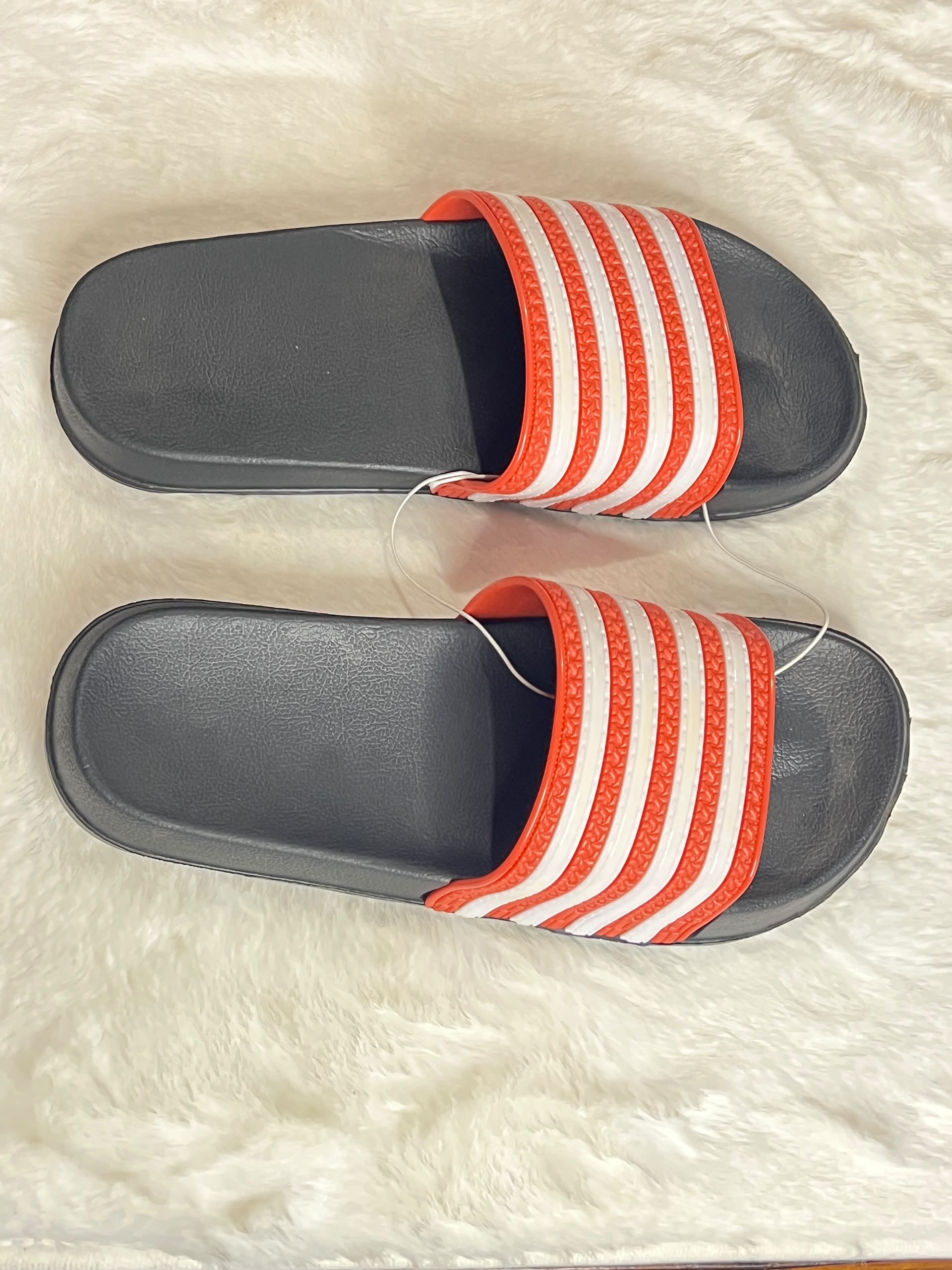 black slide sandals with red and white stripes