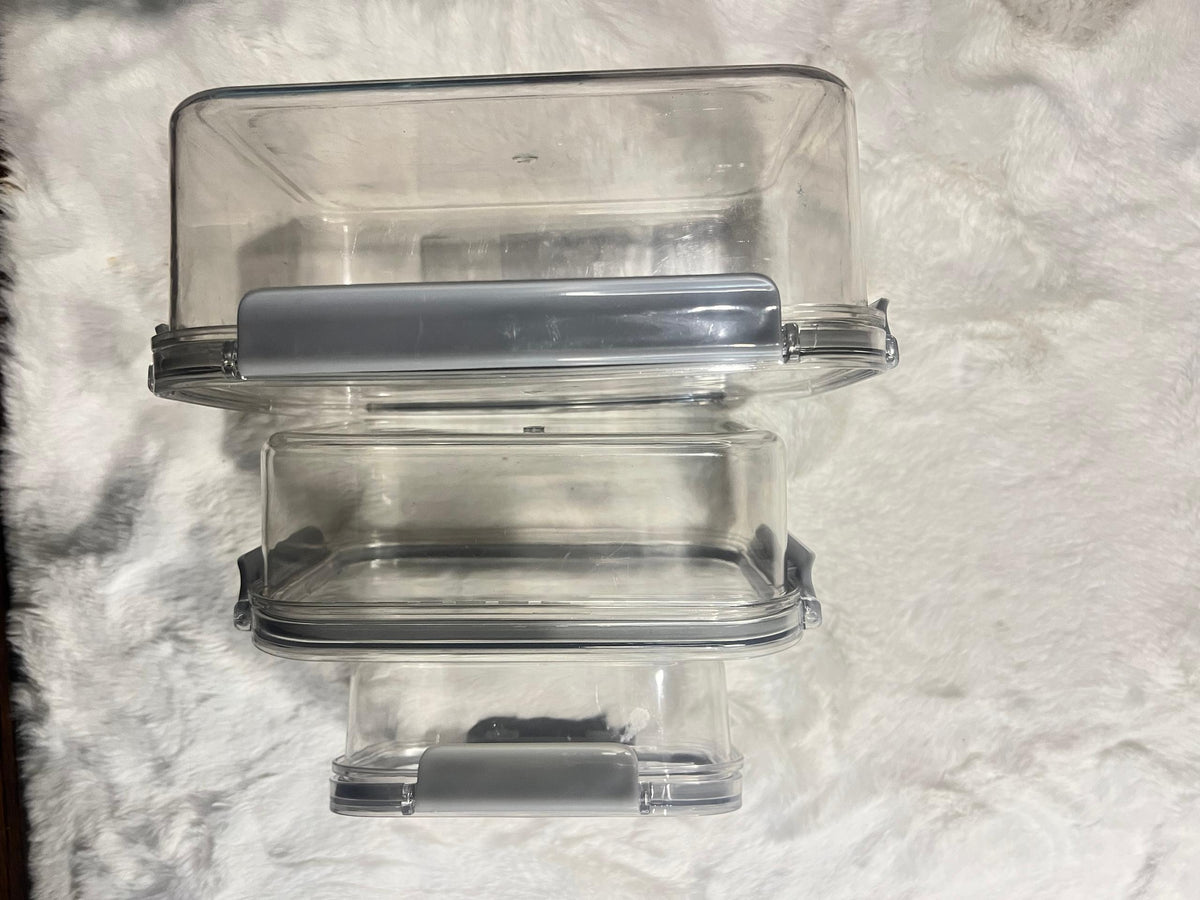 Set of four large clear plastic storage containers with gray lids