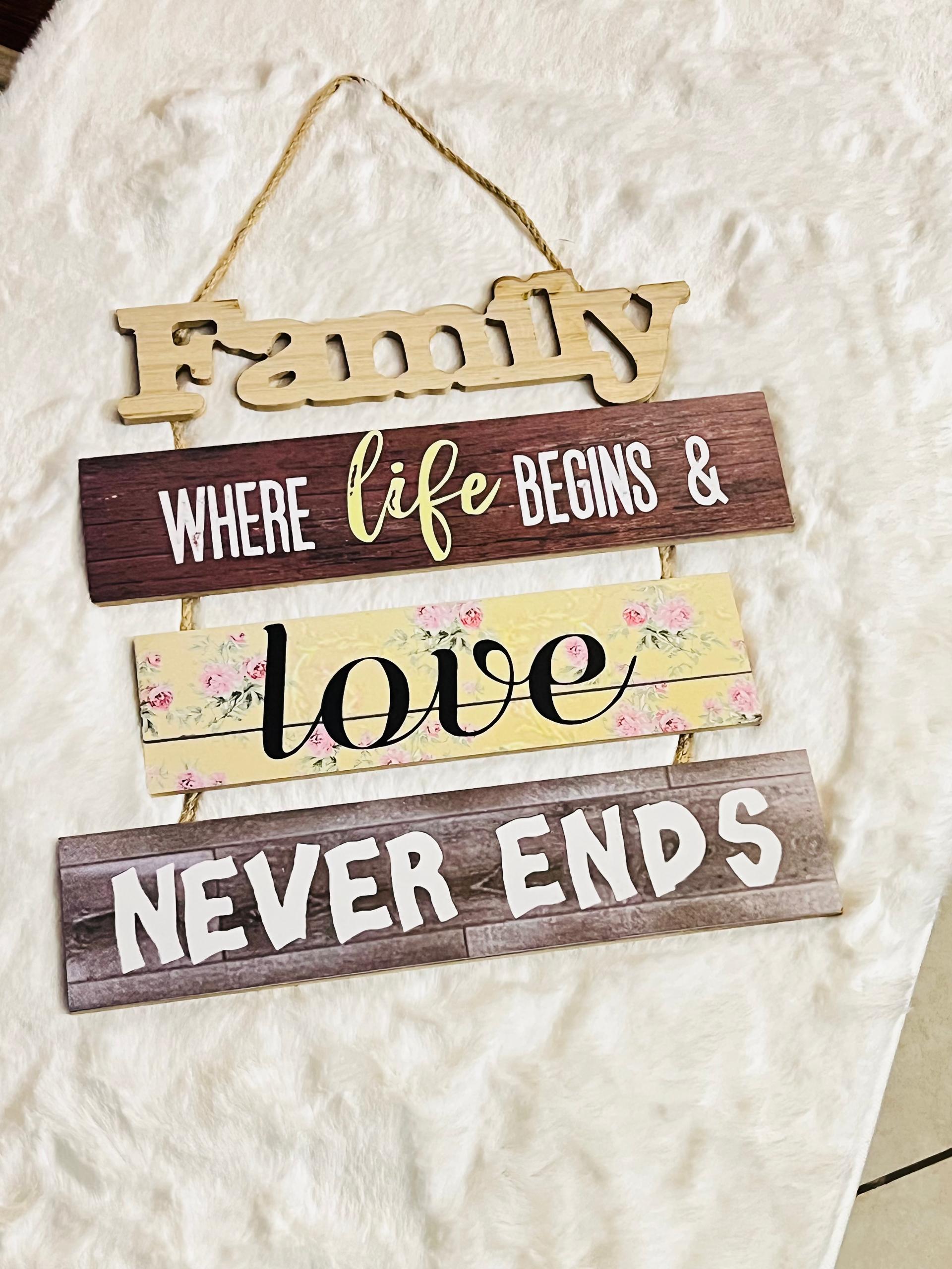 A rustic multi-tiered wooden hanging sign with the words 'Family', 'WHERE life BEGINS &', 'love' 