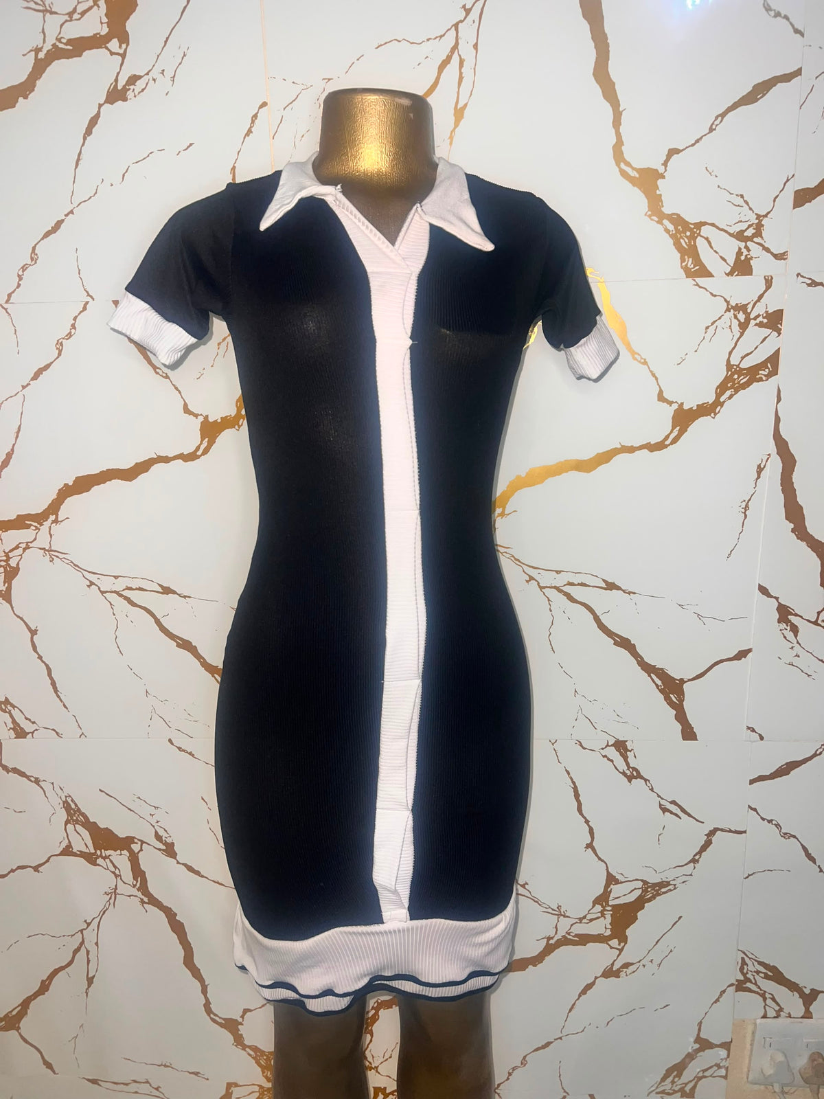 A short-sleeve black dress with white contrast trim, a white collar