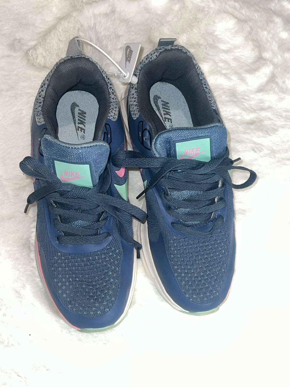 Nike running shoes in navy blue with mint green and pink accents