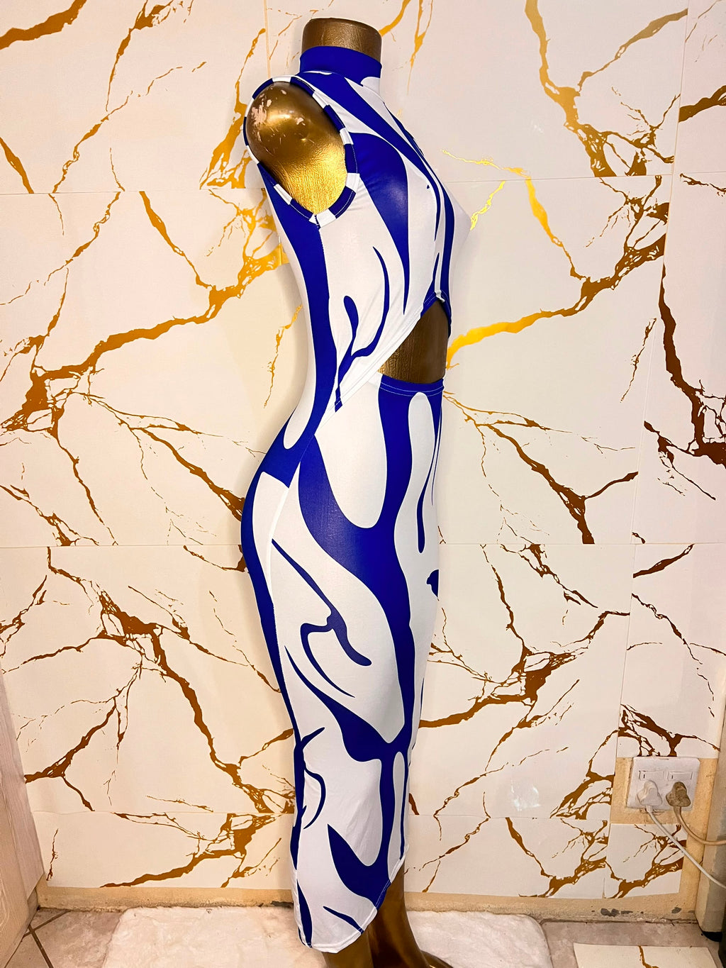 A sleeveless bodycon dress with a bold blue and white abstract wavy pattern