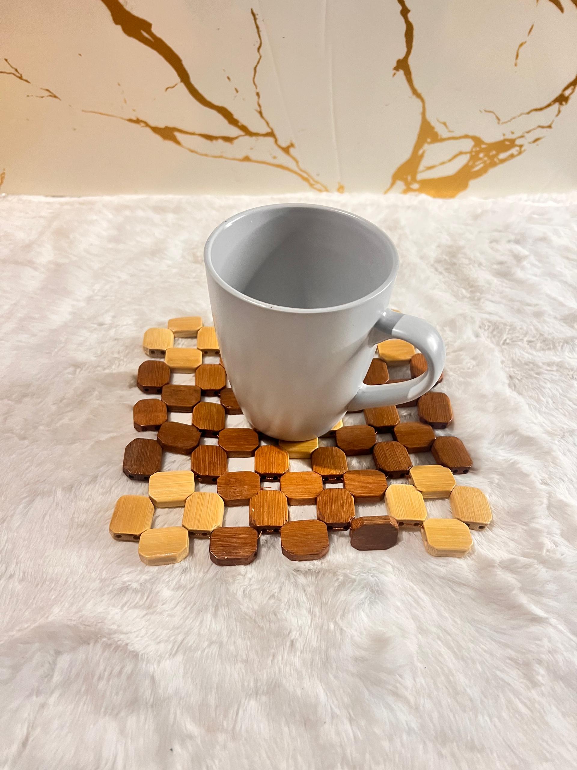 Coaster mat made of small octagonal wooden beads in various natural wood tones.