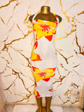 A white halter-neck bodycon dress with a bold yellow and orange hibiscus flower print
