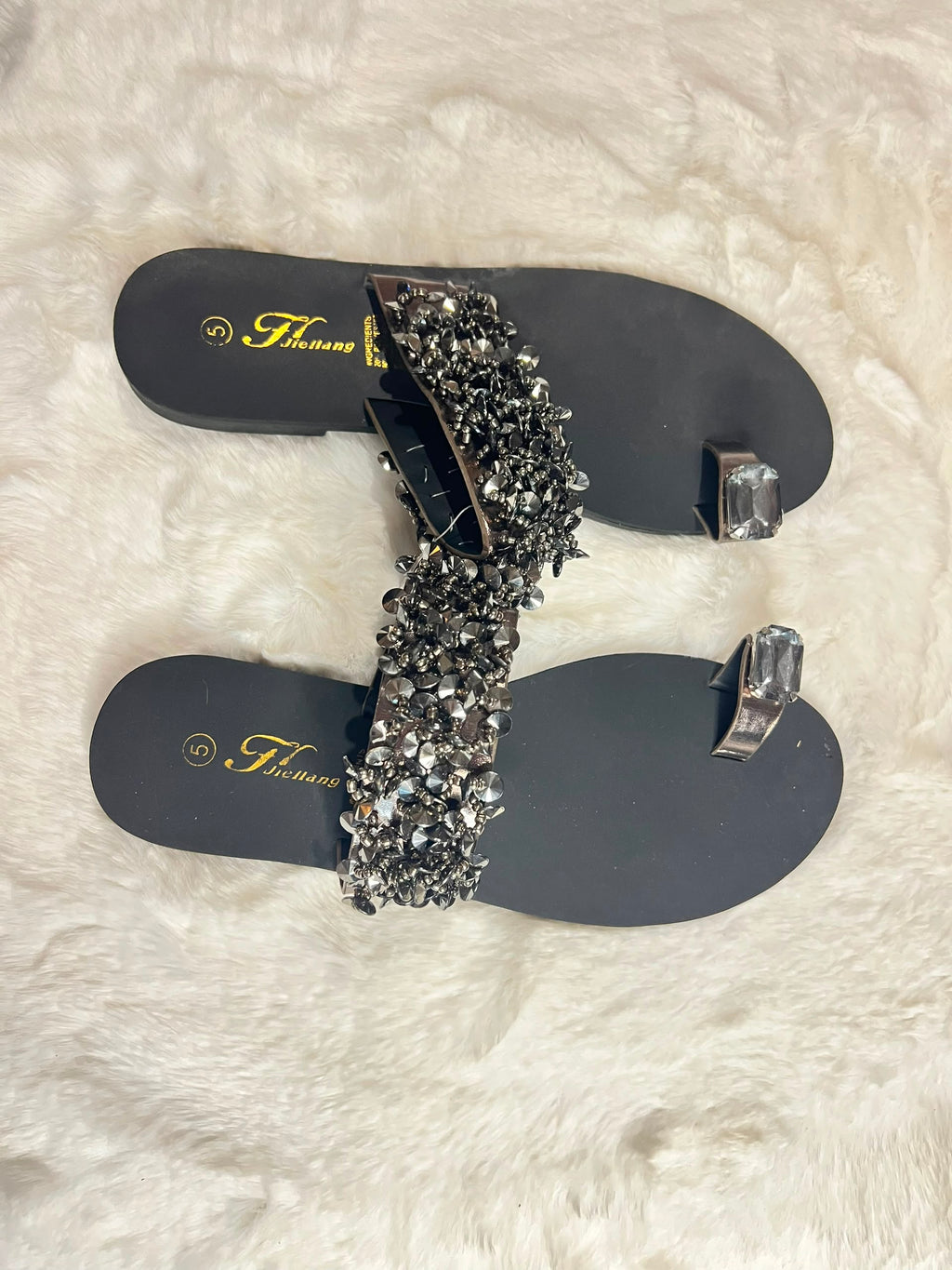 Black flat thong sandals with matching silver toe rings