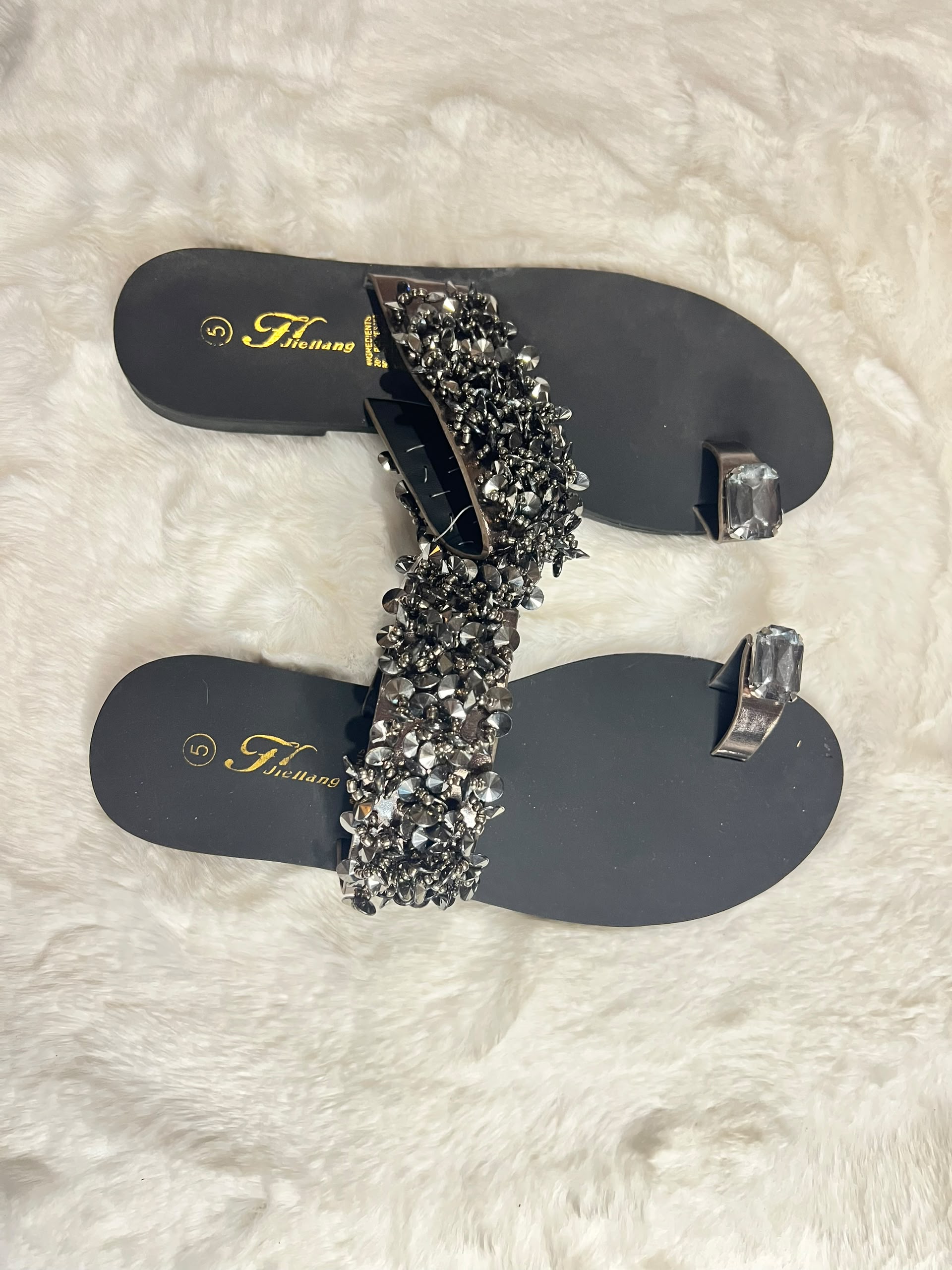 Black flat thong sandals with matching silver toe rings