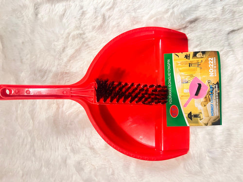 A red plastic dustpan with a wire brush