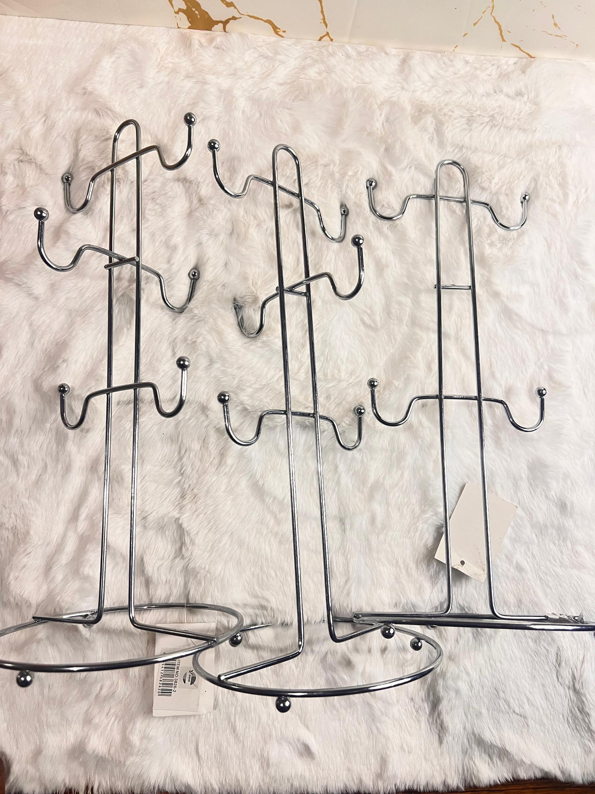 Two silver metal tea cup racks with multiple hooks