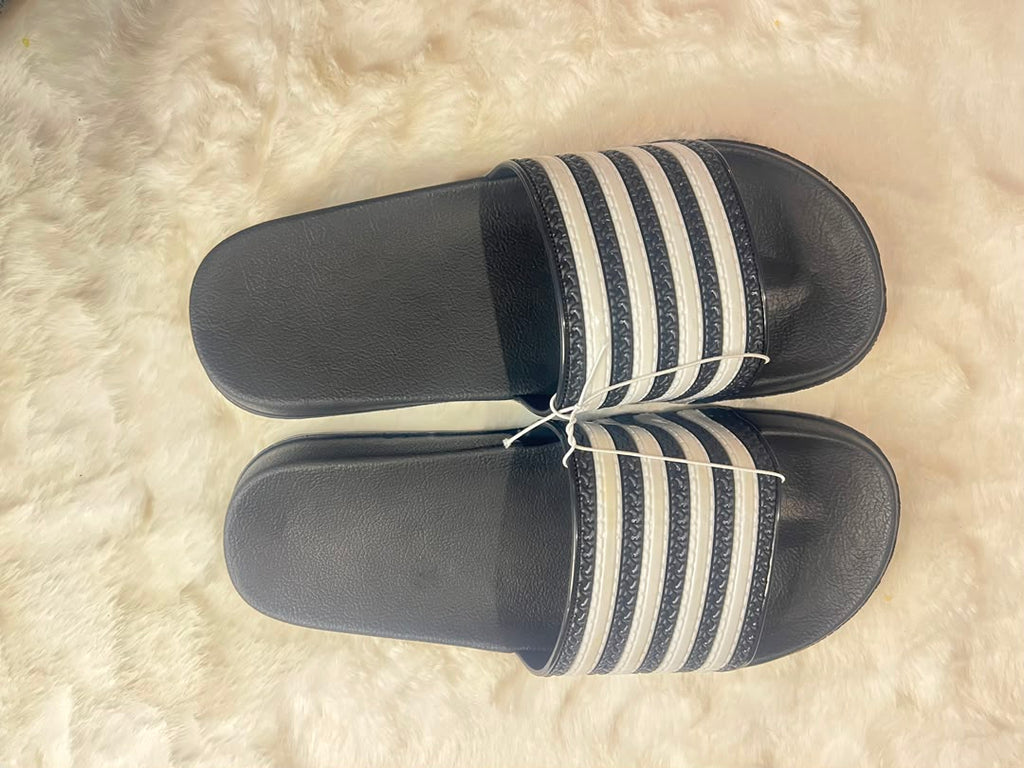 Adidas slide sandals with black footbeds and white stripes on the straps