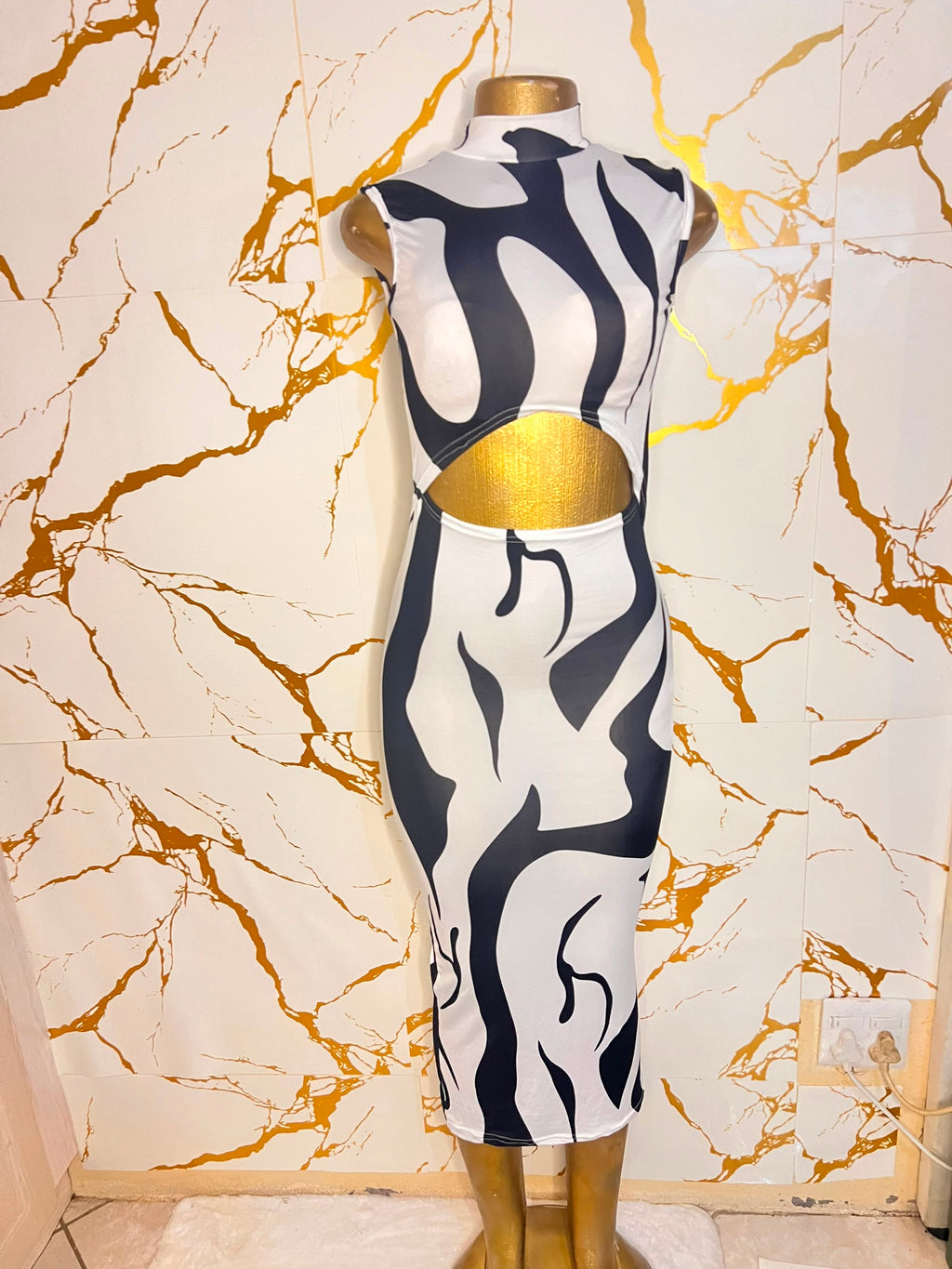 A sleeveless bodycon dress featuring a bold black and white abstract wavy pattern
