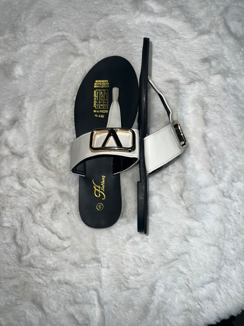 Thong sandals with wide white straps featuring large gold and black