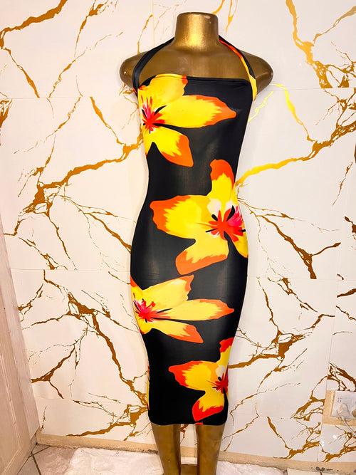 A black halter-neck bodycon dress with a vibrant yellow, orange, and red hibiscus floral print