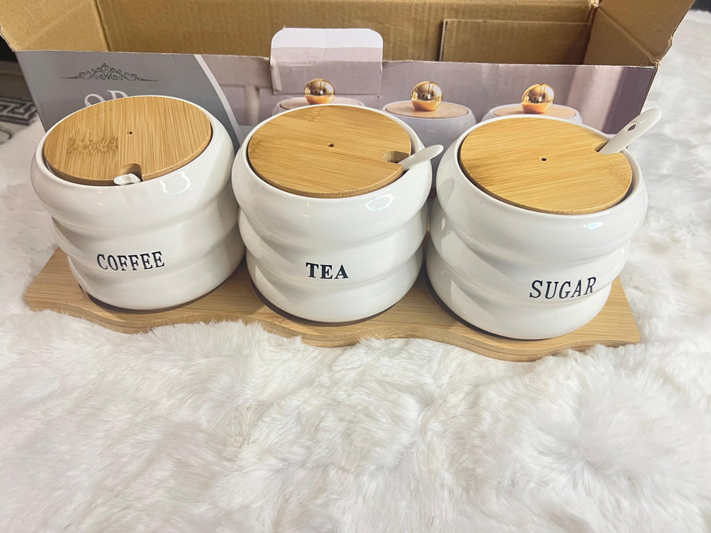 A 3-piece set of white ceramic canisters with gold lids