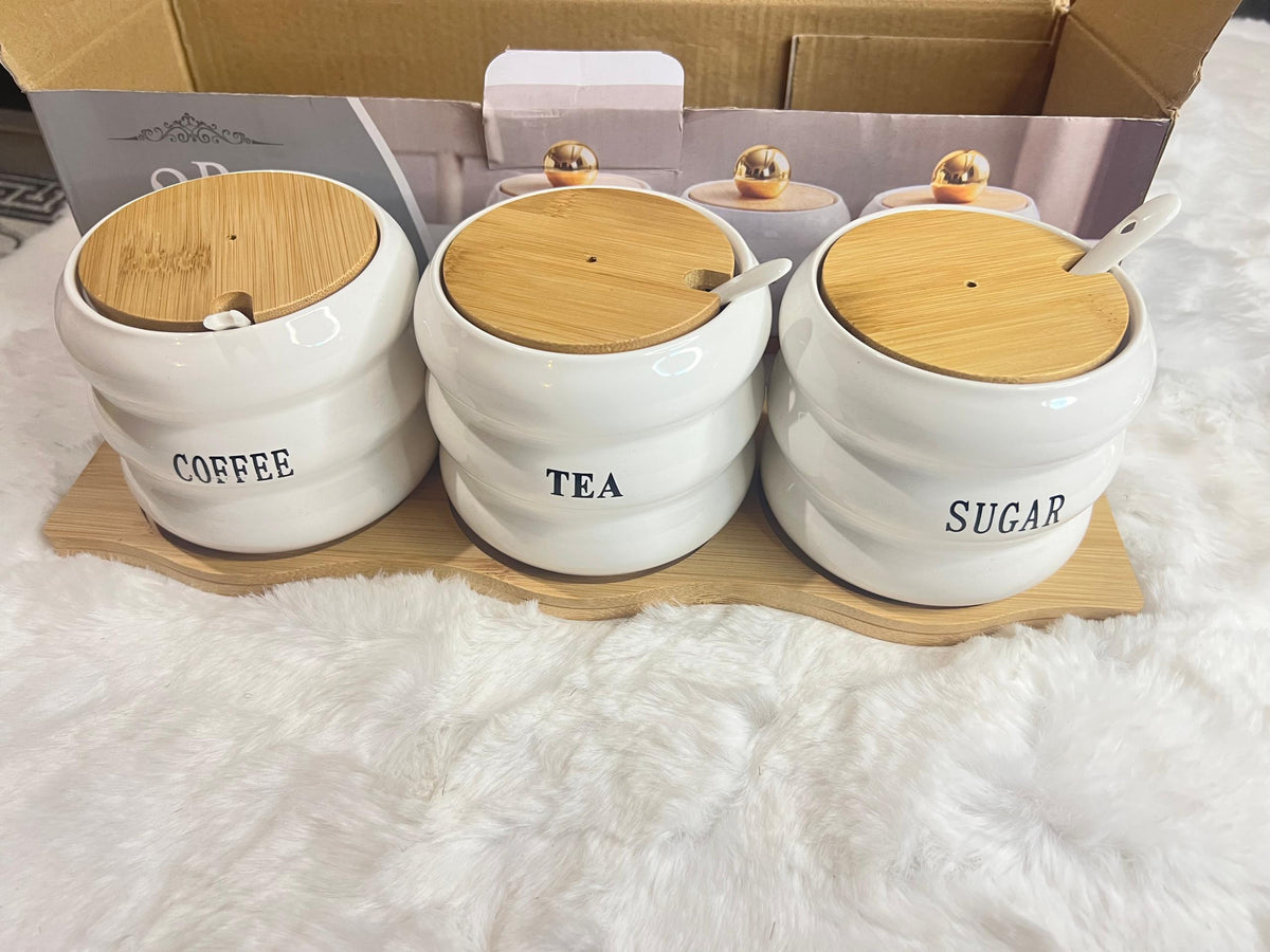 A 3-piece set of white ceramic canisters with gold lids