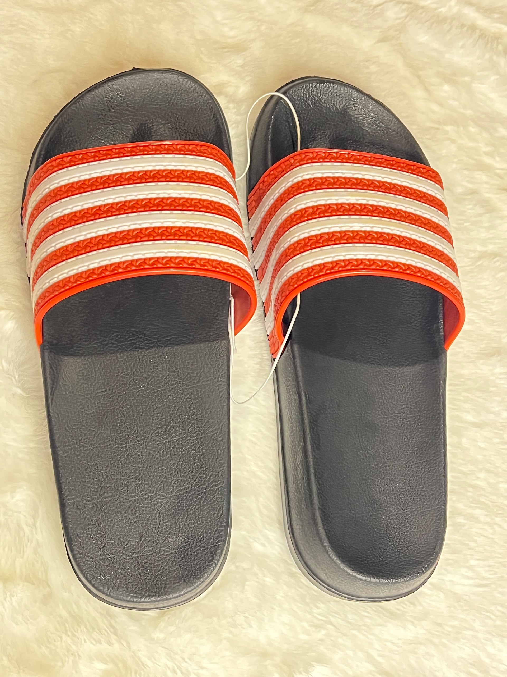 black slide sandals with red and white stripes