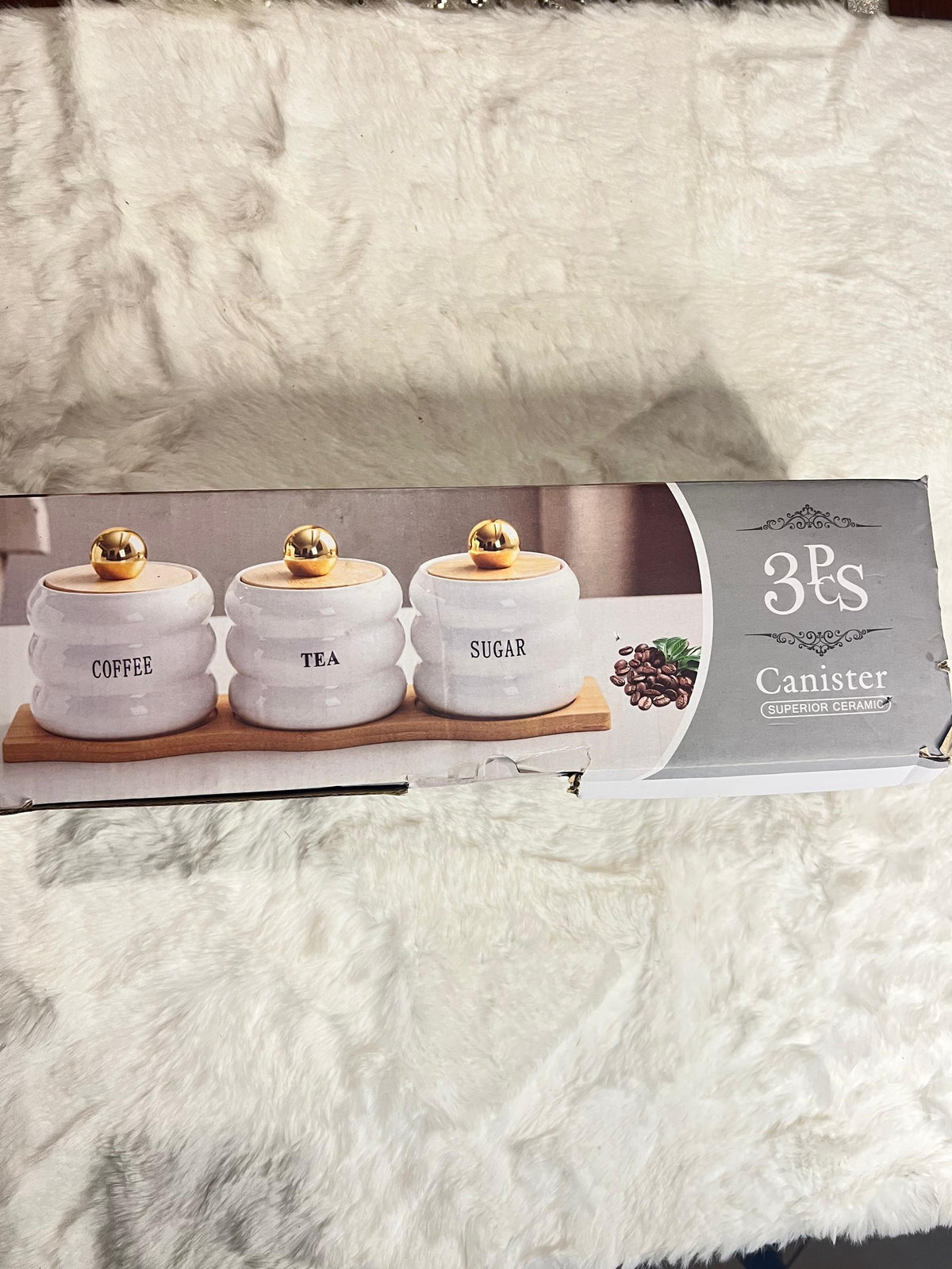 A 3-piece set of white ceramic canisters with gold lids