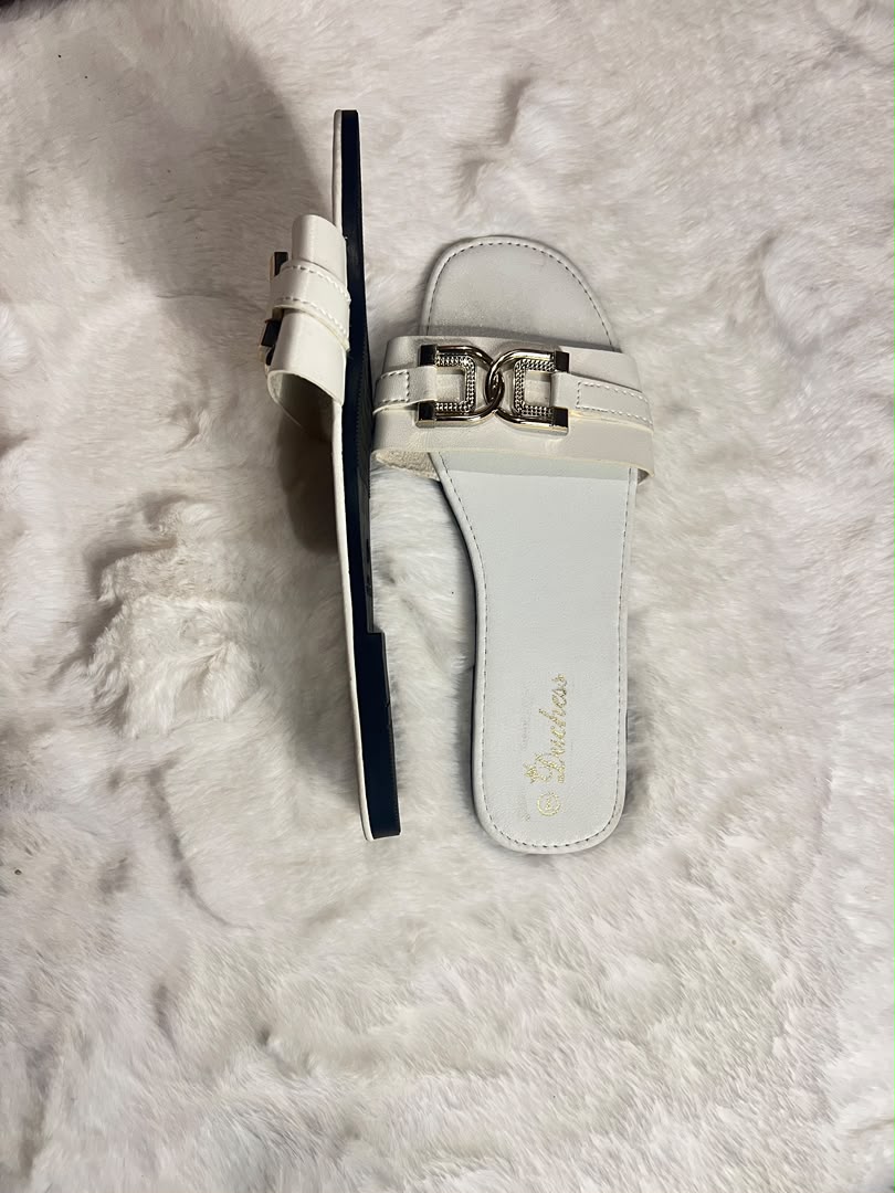 White slide sandals with metallic gold hardware