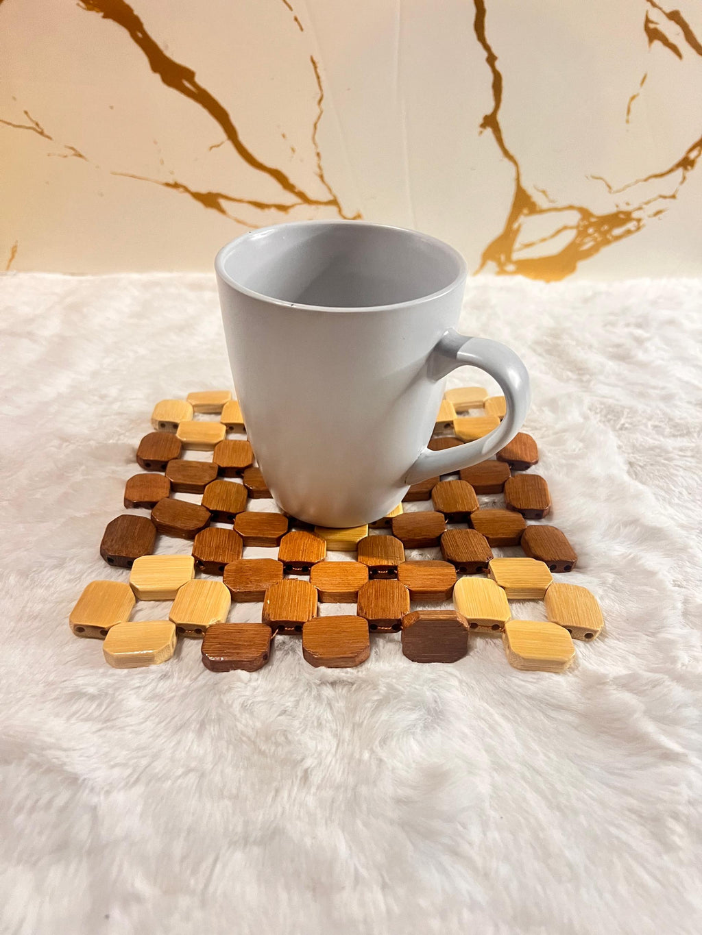 Coaster mat made of small octagonal wooden beads in various natural wood tones.