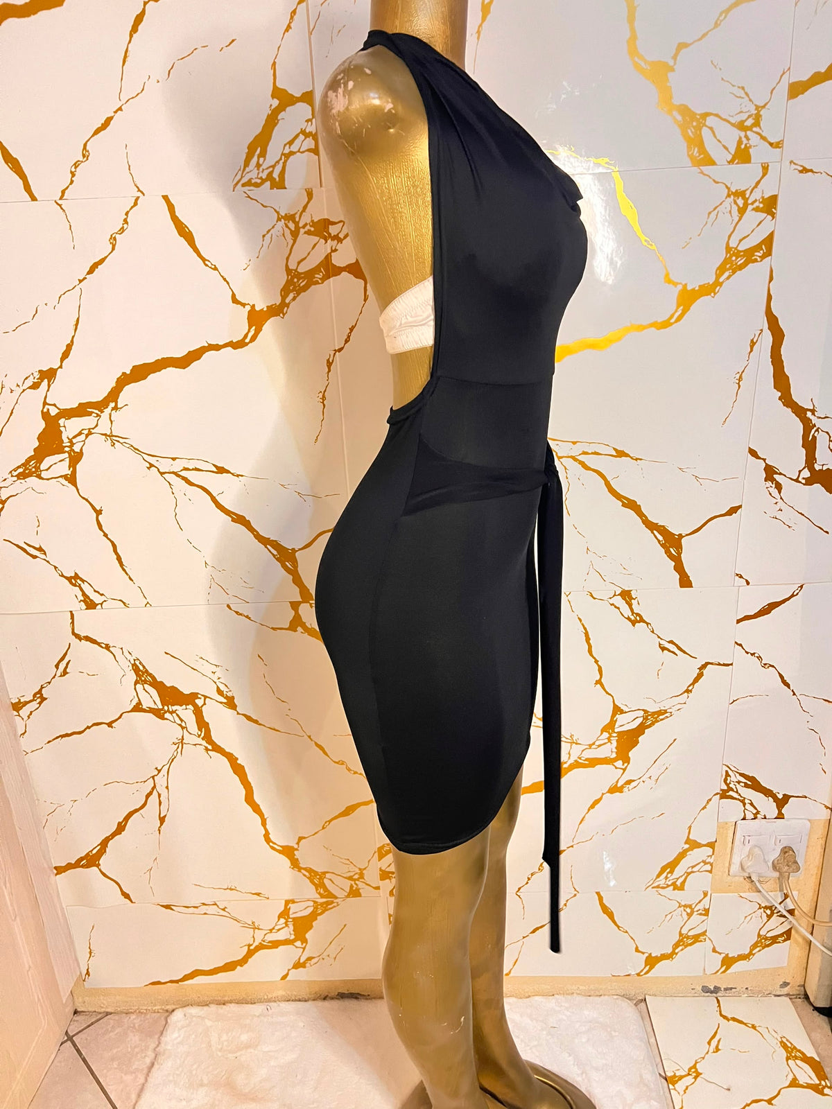 A sleeveless black cowl-neck mini dress with a tie waist