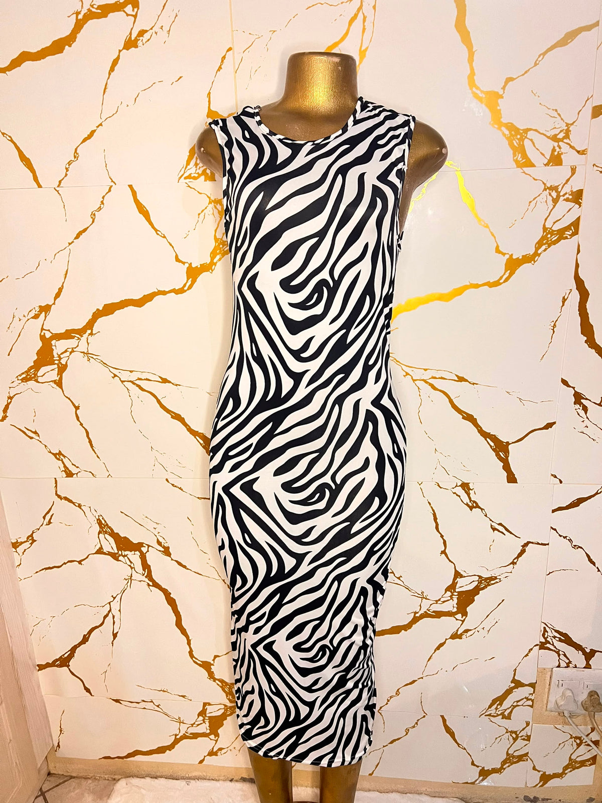 A sleeveless black and white zebra-patterned midi dress 