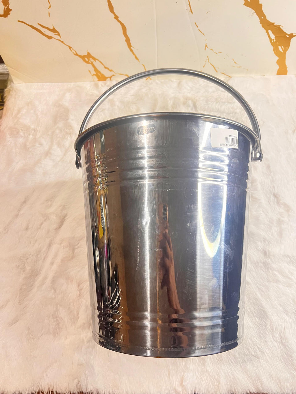 A shiny silver ice metal bucket with a curved handle