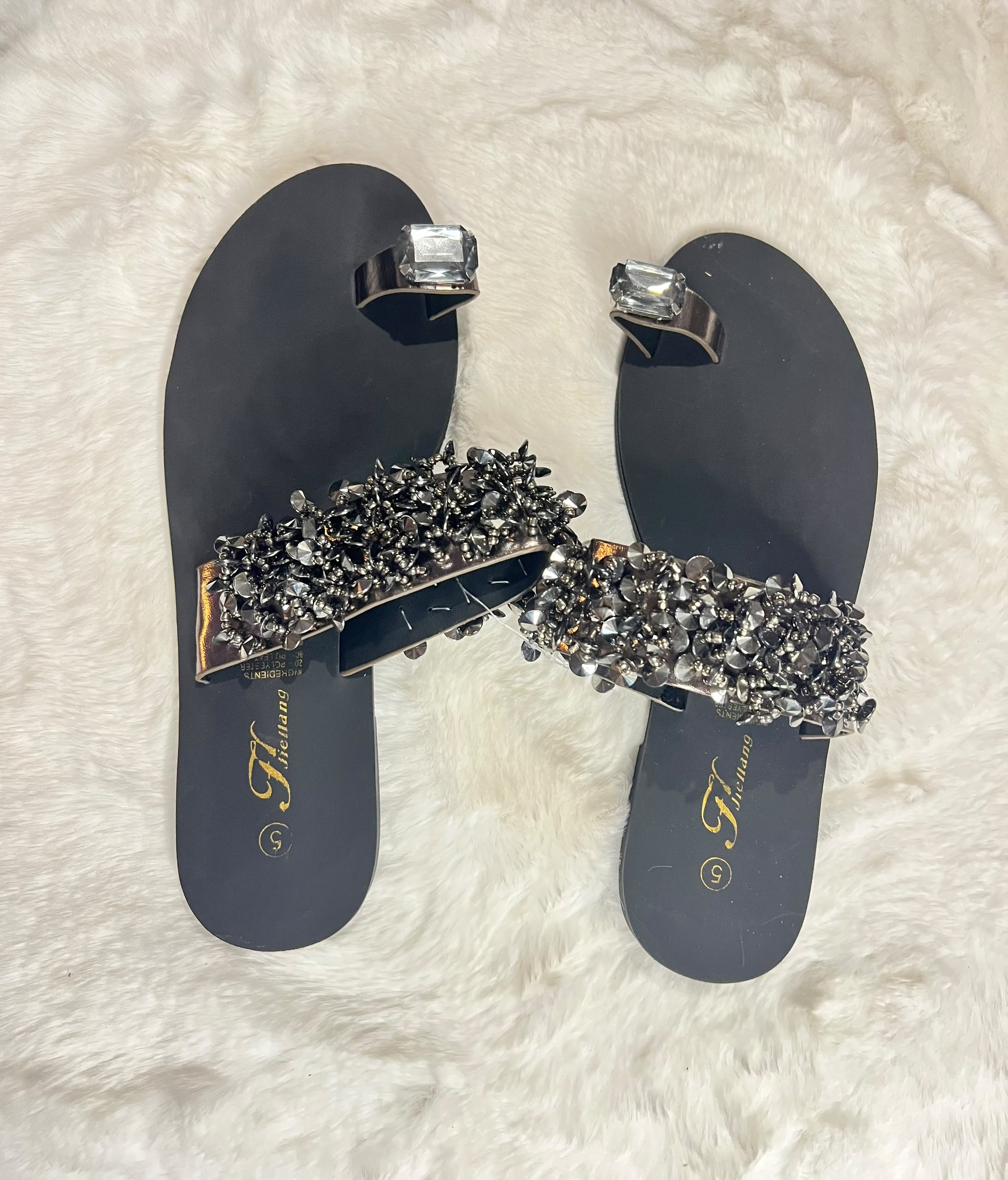 Black flat thong sandals with matching silver toe rings