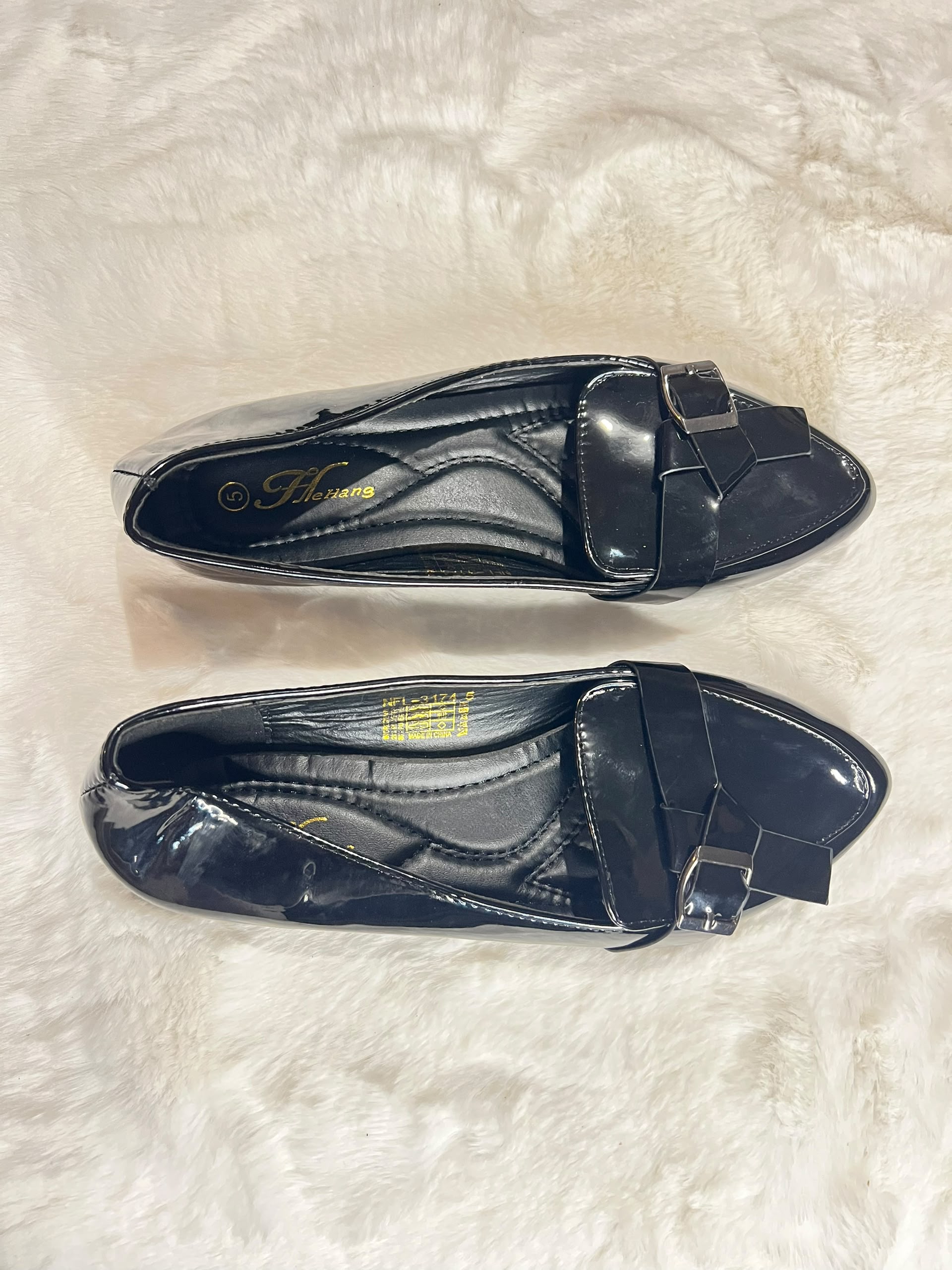 Black patent leather loafers with a bow