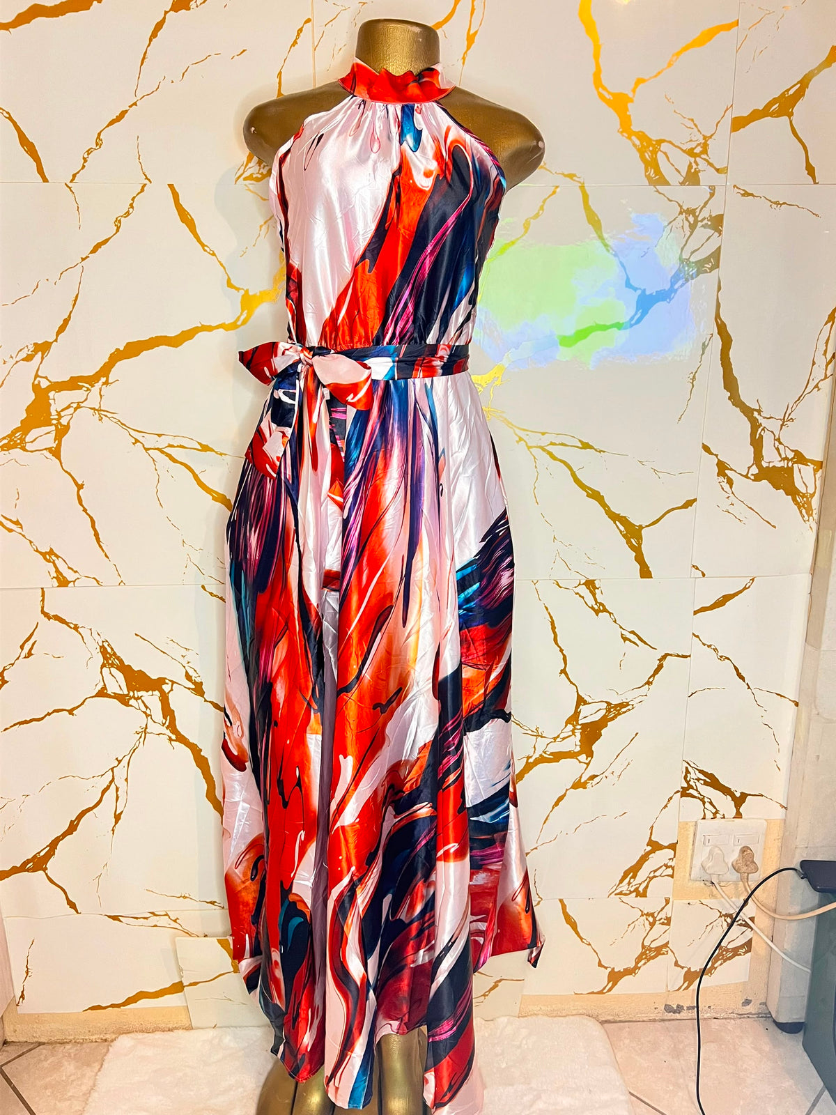 A sleeveless halter-neck maxi dress with a colorful abstract print