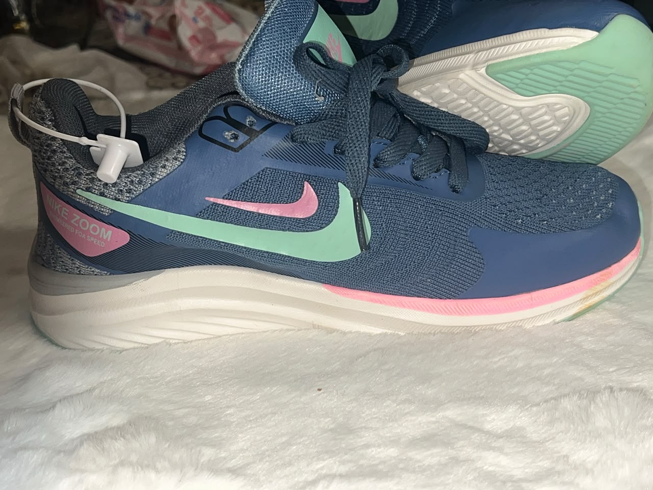 Nike running shoes in navy blue with mint green and pink accents
