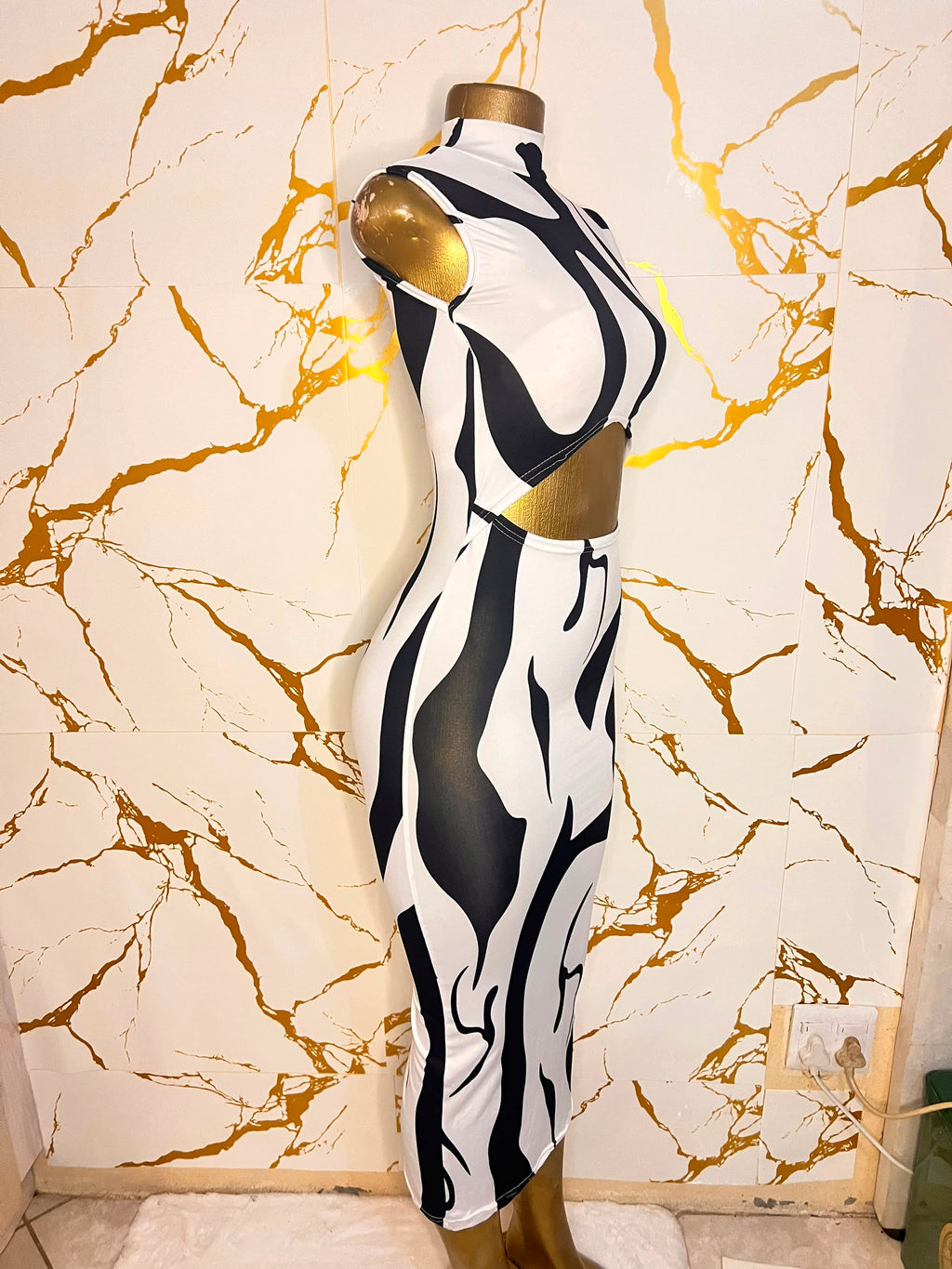 A sleeveless bodycon dress featuring a bold black and white abstract wavy pattern