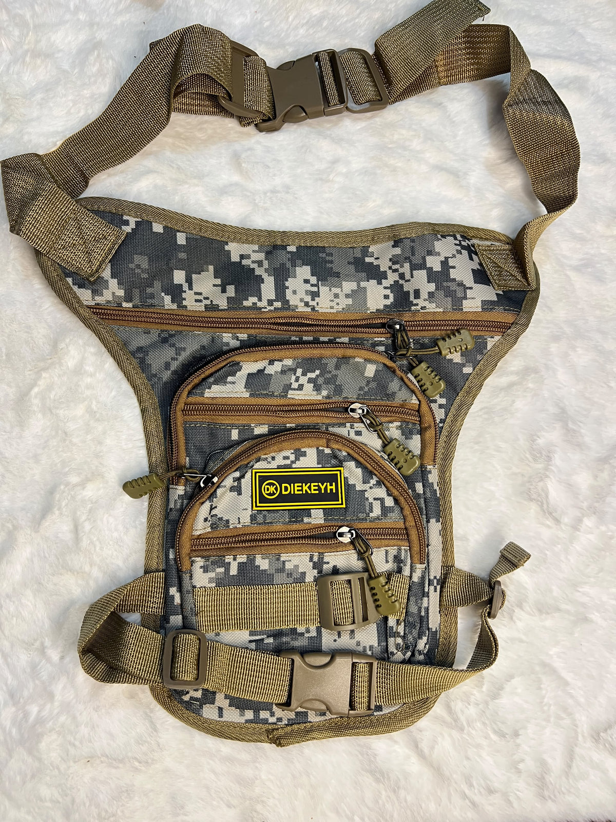 A tactical chest rig bag in digital camouflage pattern with tan webbing straps
