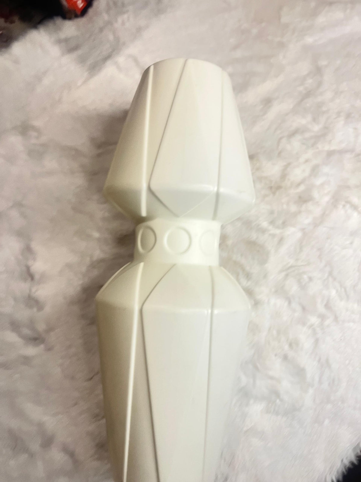 A cream-colored geometric decorative vase