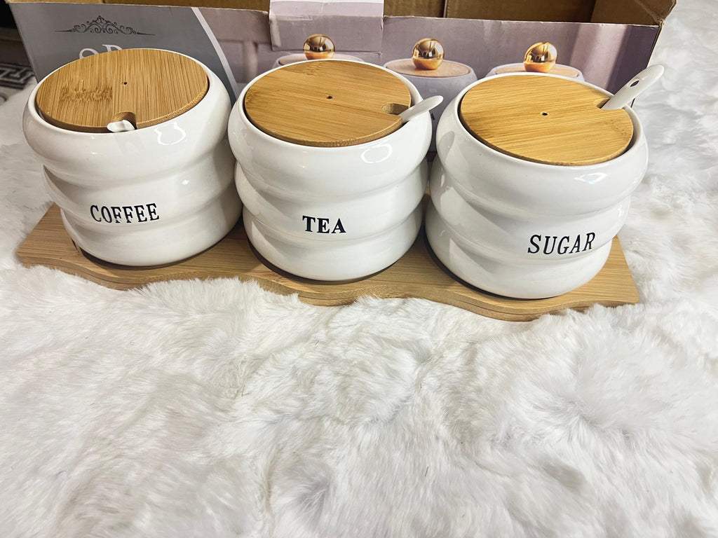 A 3-piece set of white ceramic canisters with gold lids