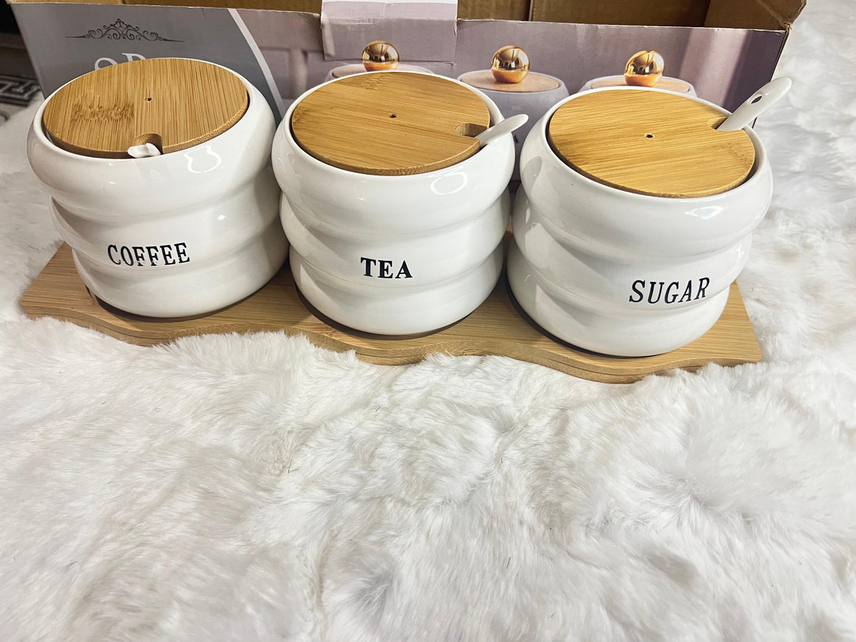 A 3-piece set of white ceramic canisters with gold lids