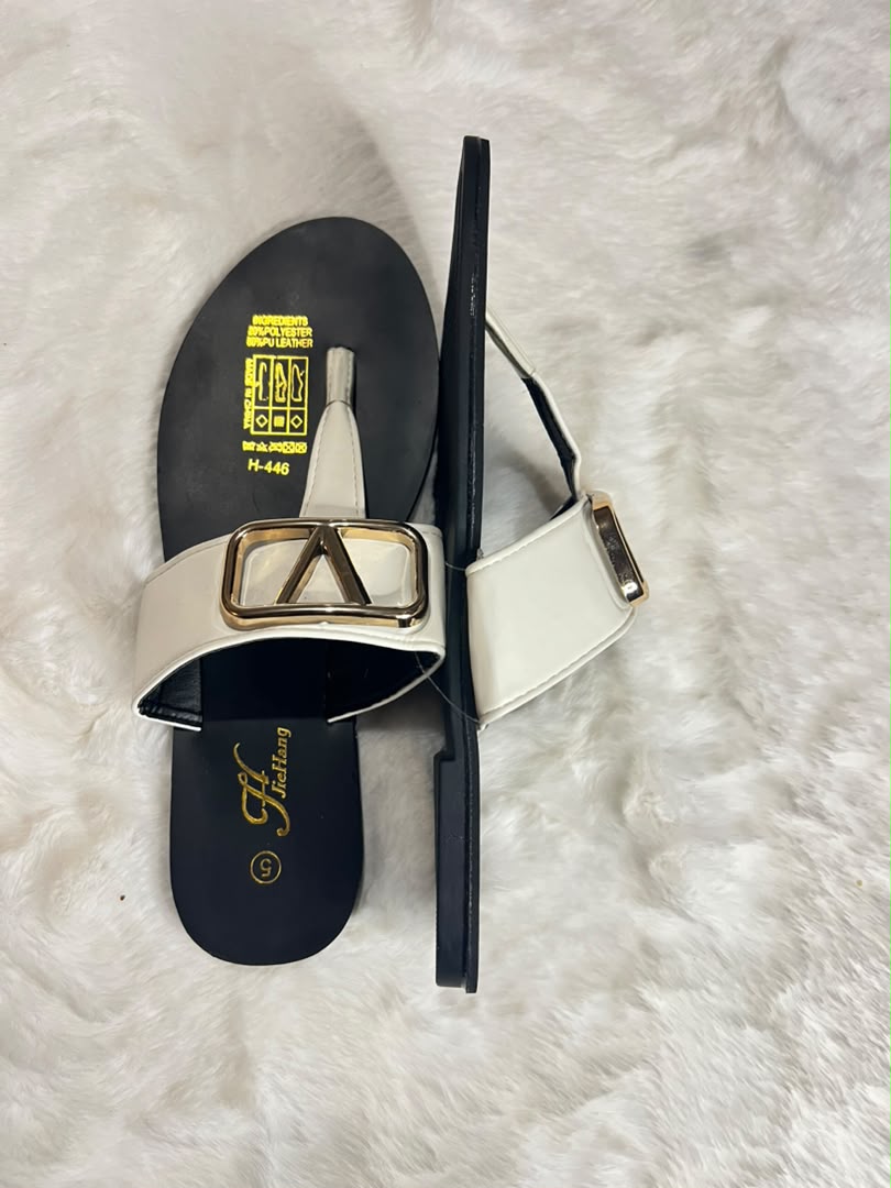 Thong sandals with wide white straps featuring large gold and black