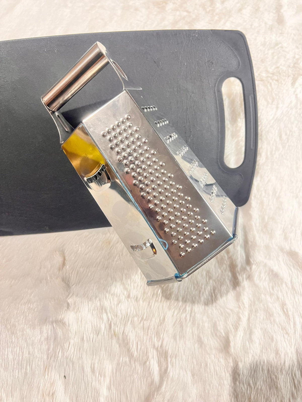 Stainless steel box grater with a dark gray handle