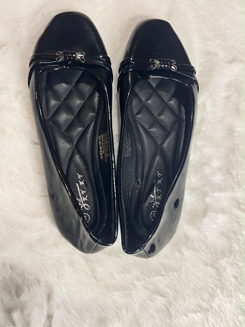 Black quilted leather ballet flats with metallic silver bow details on the toes