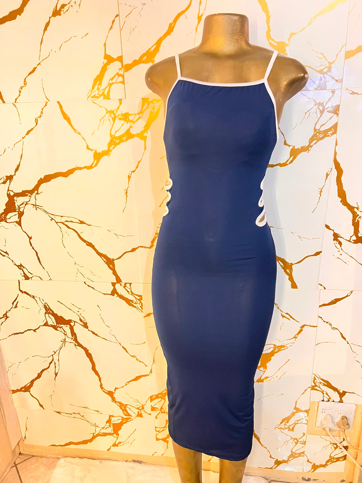 A navy blue bodycon midi dress with white trim and side cutouts