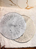 Two round decorative plates with starburst and star patterns, one in silver and one in gold