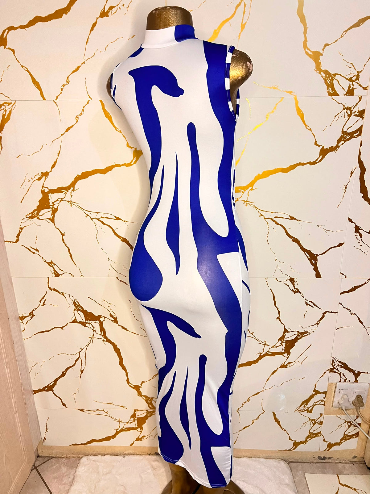 A sleeveless bodycon dress with a bold blue and white abstract wavy pattern