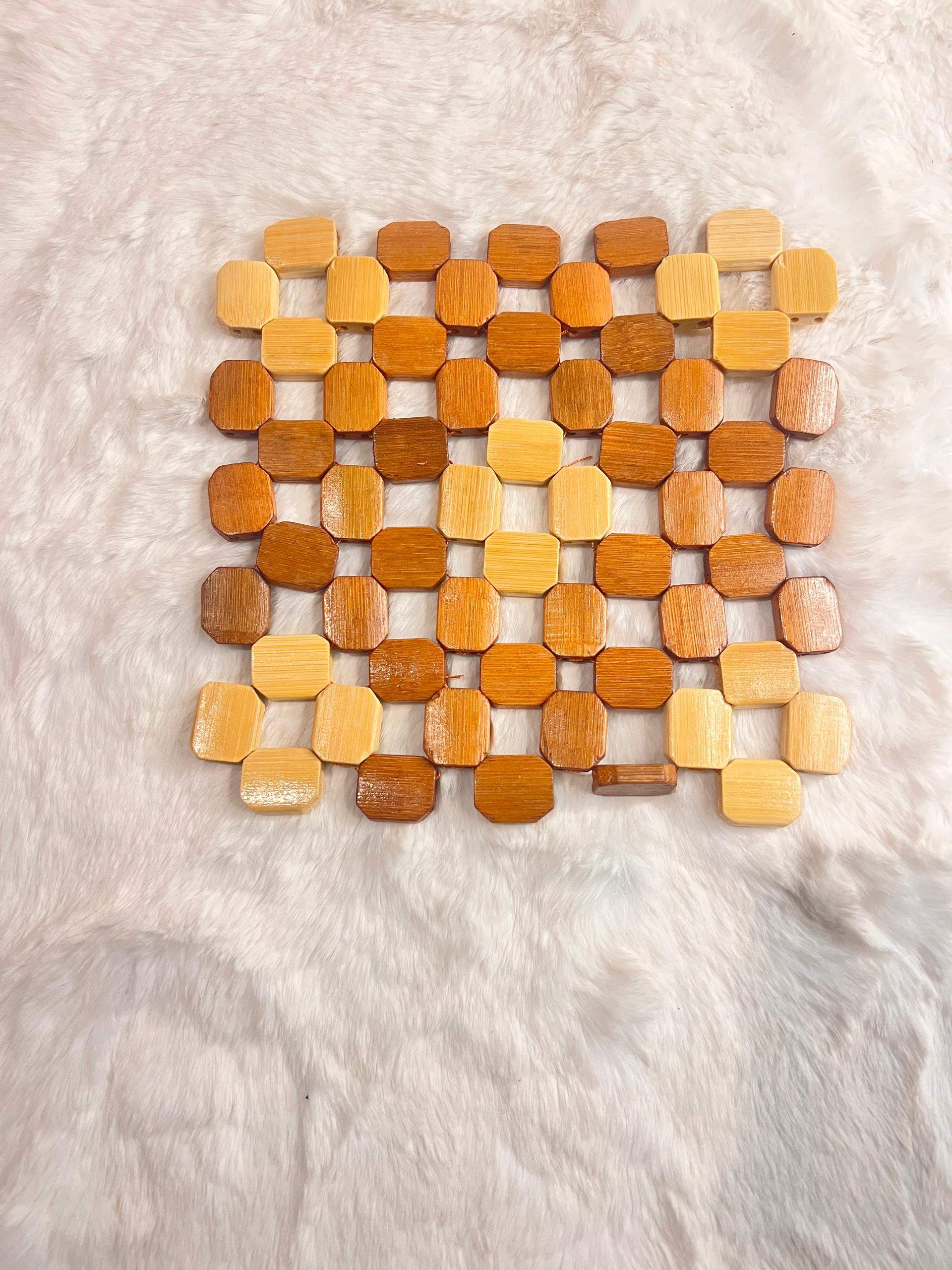 Coaster mat made of small octagonal wooden beads in various natural wood tones.